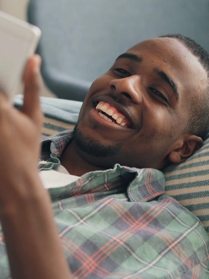 Homme souriant consultant son smartphone, illustrant un cas client lié à la délivrabilité email et à la bonne réception des messages.