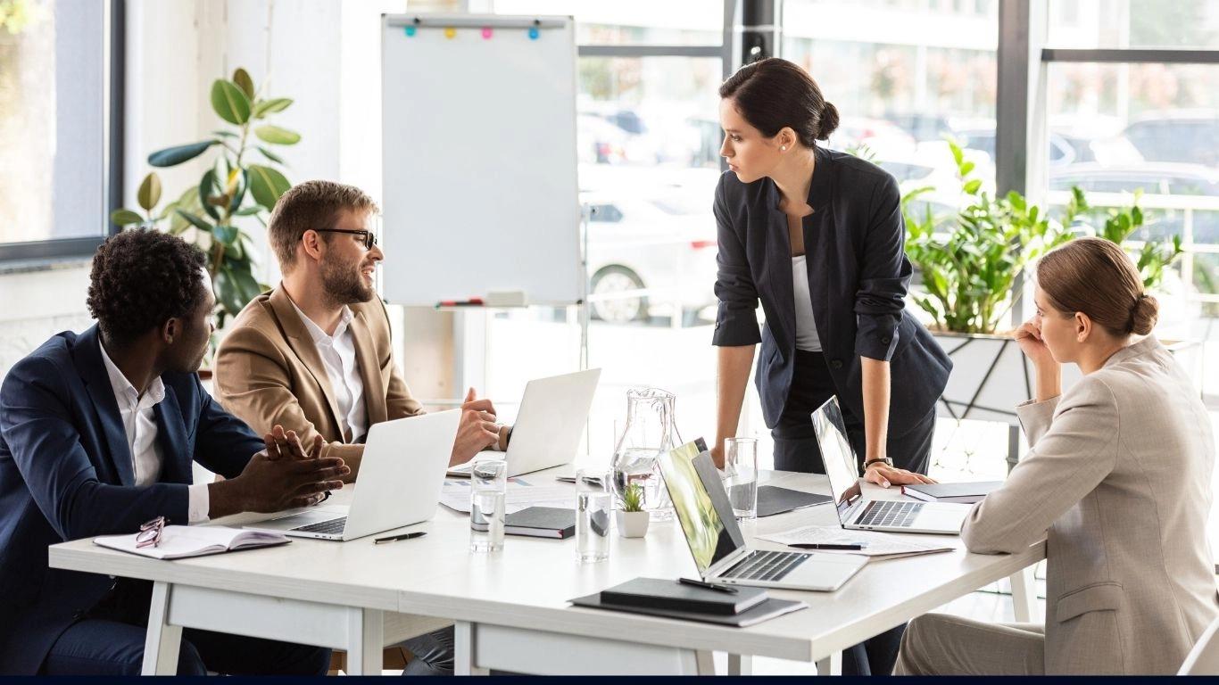 Équipe en formation autour d’une table de réunion, illustrant une session de formation HTML email de niveau avancé.
