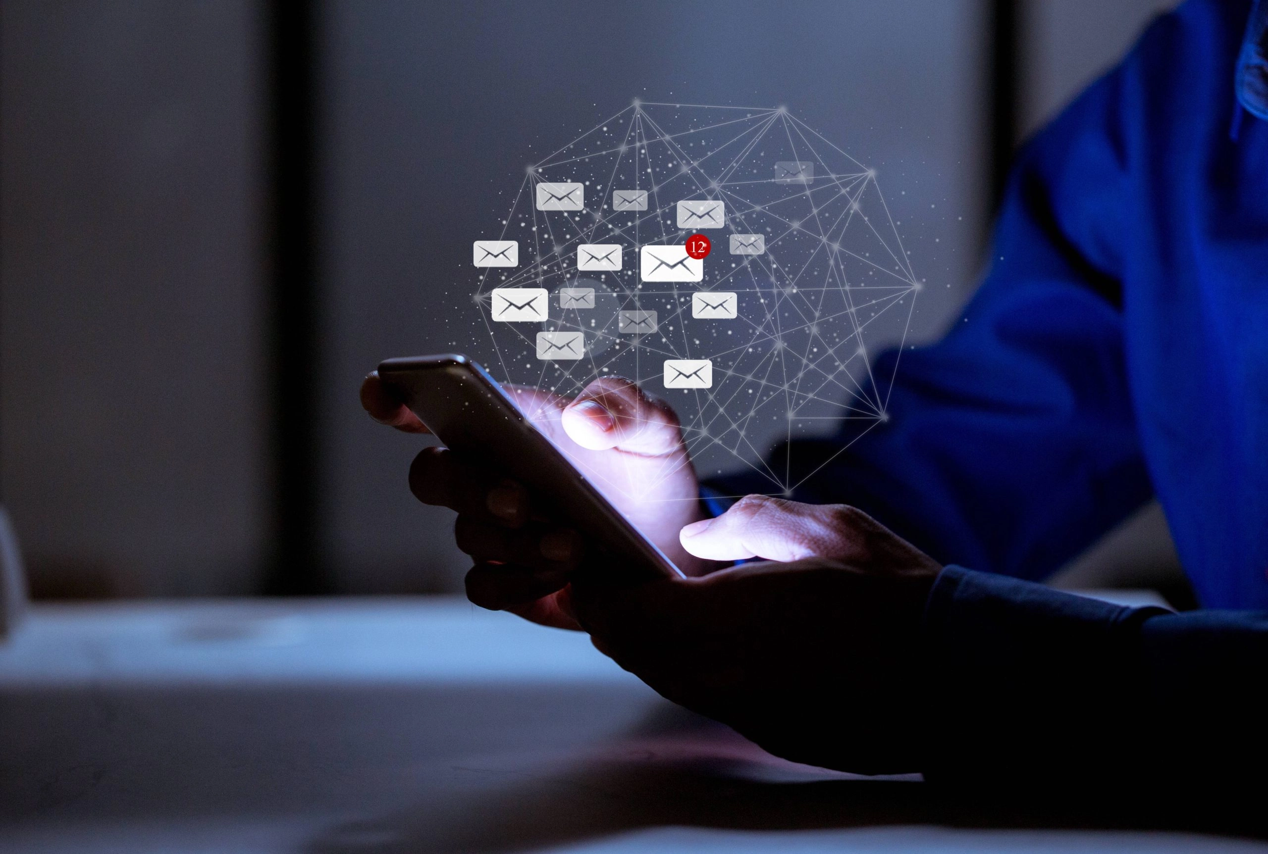 Personne utilisant un smartphone avec des notifications e-mail connectées, illustration de l’accompagnement délivrabilité.