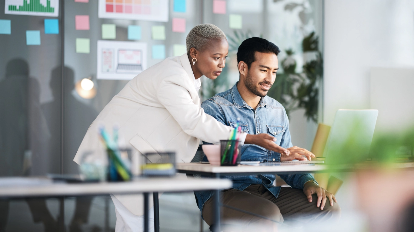 Deux professionnels travaillant ensemble sur ordinateur, illustrant une formation dédiée aux performances email et à la délivrabilité.