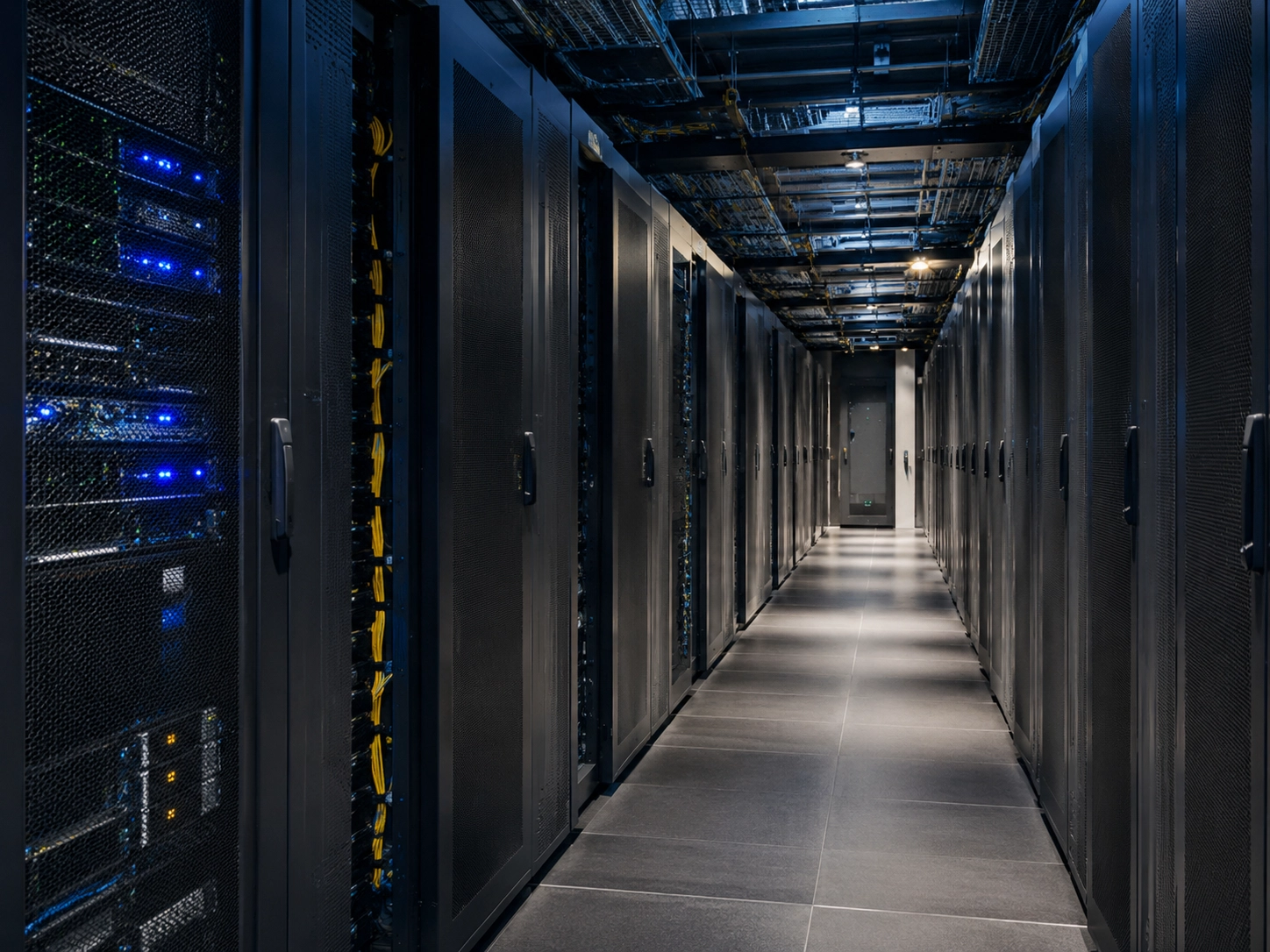 Salle de data center avec baies de serveurs sécurisées, illustrant l’hébergement et la protection des données.