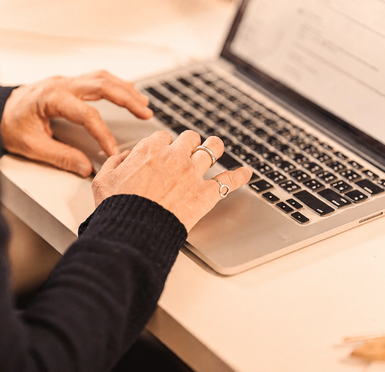 Mains travaillant sur un ordinateur portable, illustrant l’automatisation des communications et la gestion des campagnes digitales.