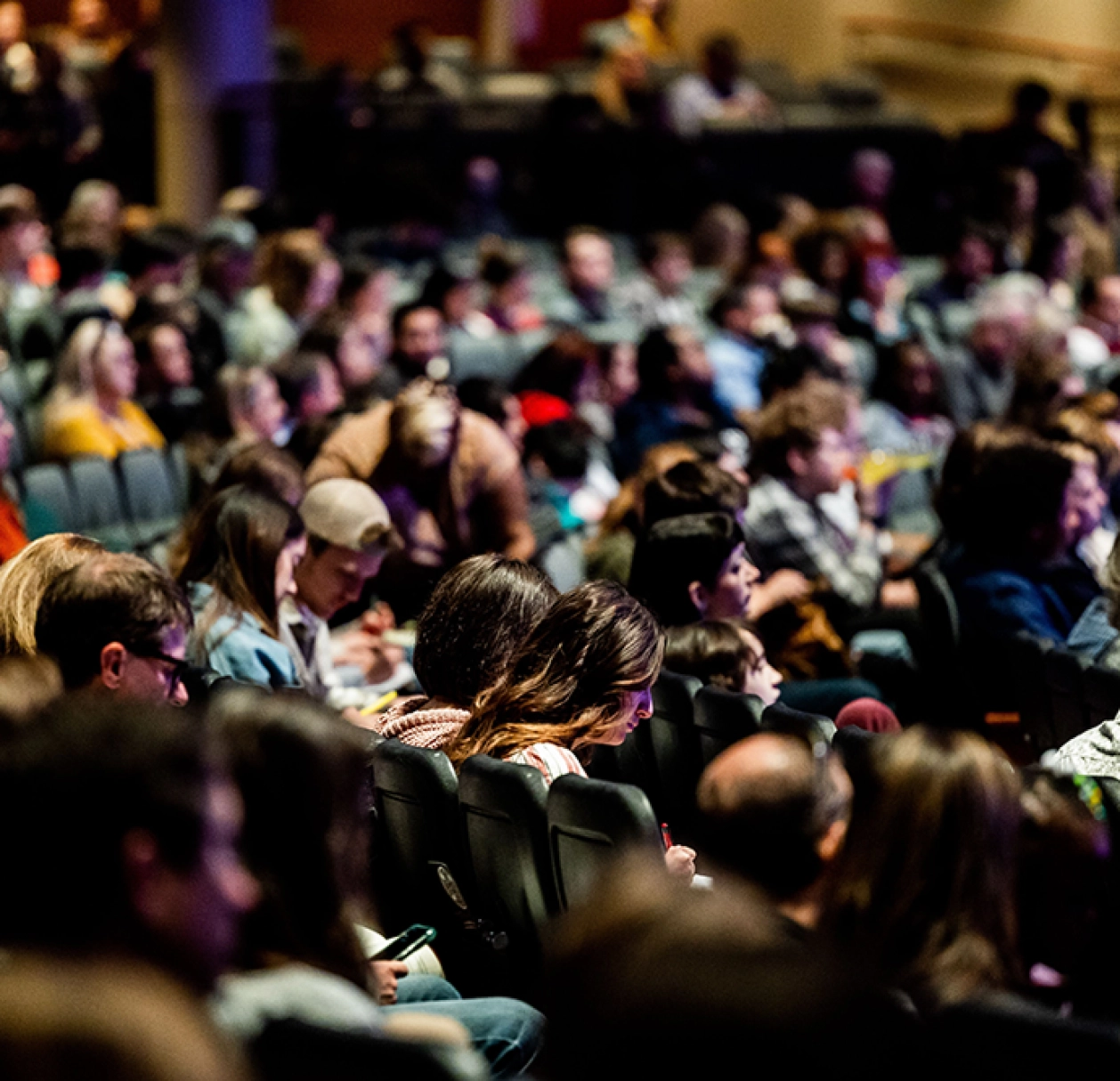 Audience réunie dans une salle de conférence, illustration de la communication avec différents publics.
