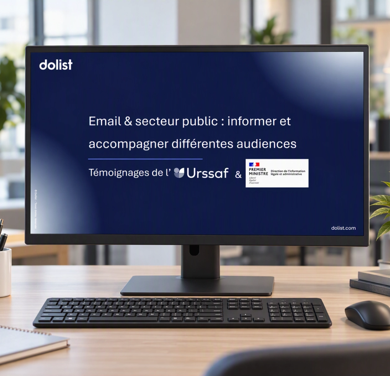 Écran d’ordinateur professionnel dans un environnement de bureau moderne affichant la couverture d’un webinaire Dolist intitulé « Email & secteur public : informer et accompagner différentes audiences », avec les logos de l’Urssaf et de la Direction de l’information légale et administrative (DILA).