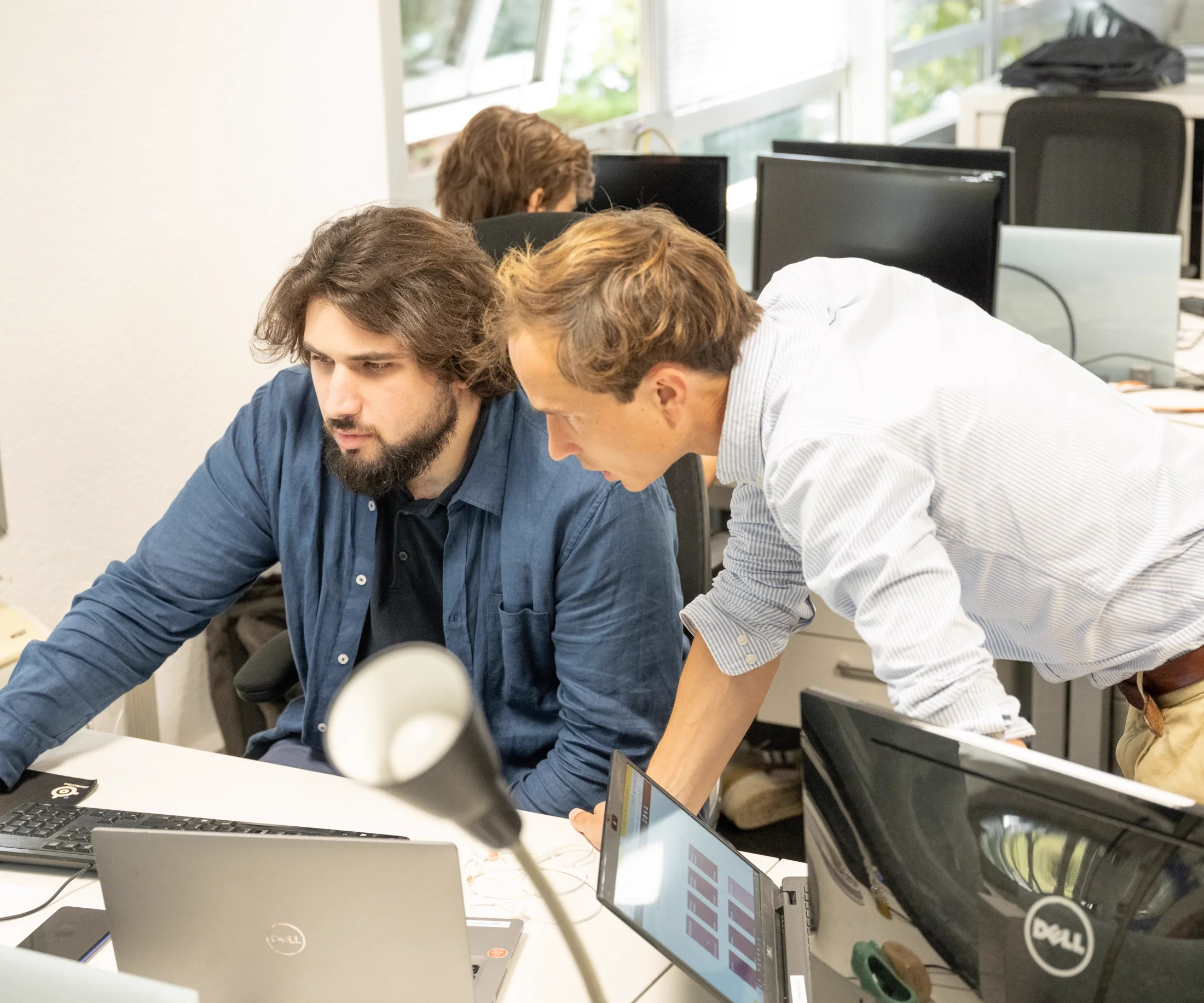 Deux collaborateurs Dolist travaillant ensemble devant un écran dans les locaux de Dolist