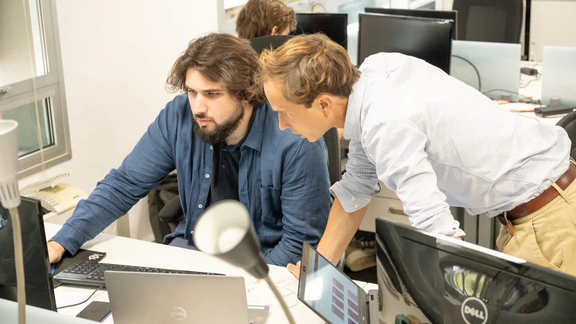 Deux collaborateurs Dolist travaillant ensemble devant un écran